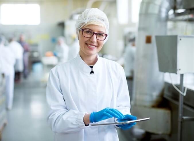 Woman with tablet in food manufacturing facility